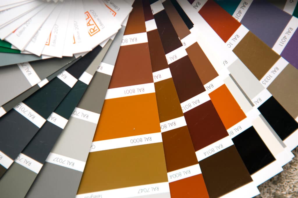 Selection of the paint color for decorative home repairs to the palette with layouts. A fan of shades in your hand inside the home. Repair and construction, paint and varnish coating